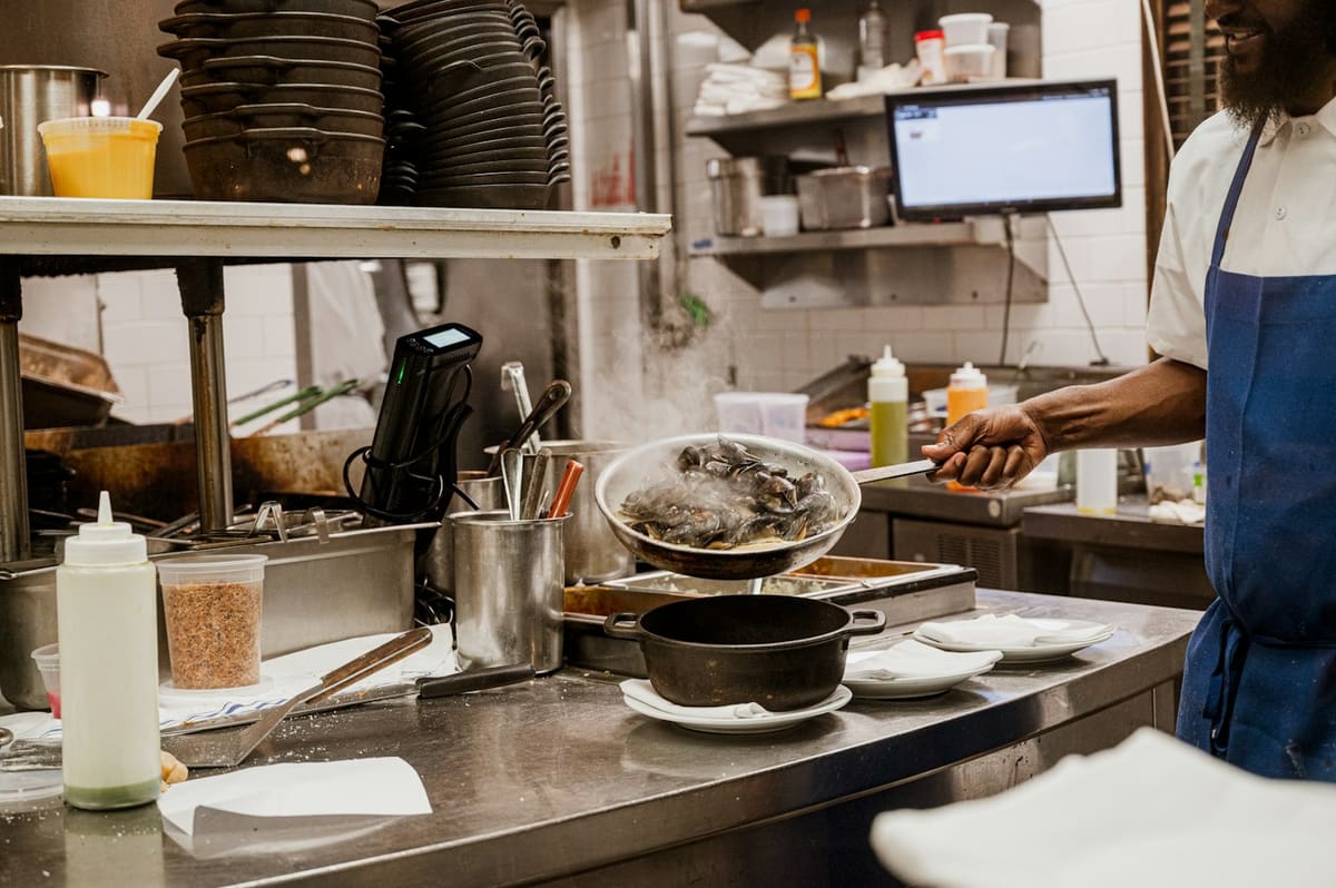Cocinero trabajando en la cocina de un restaurante pequeño